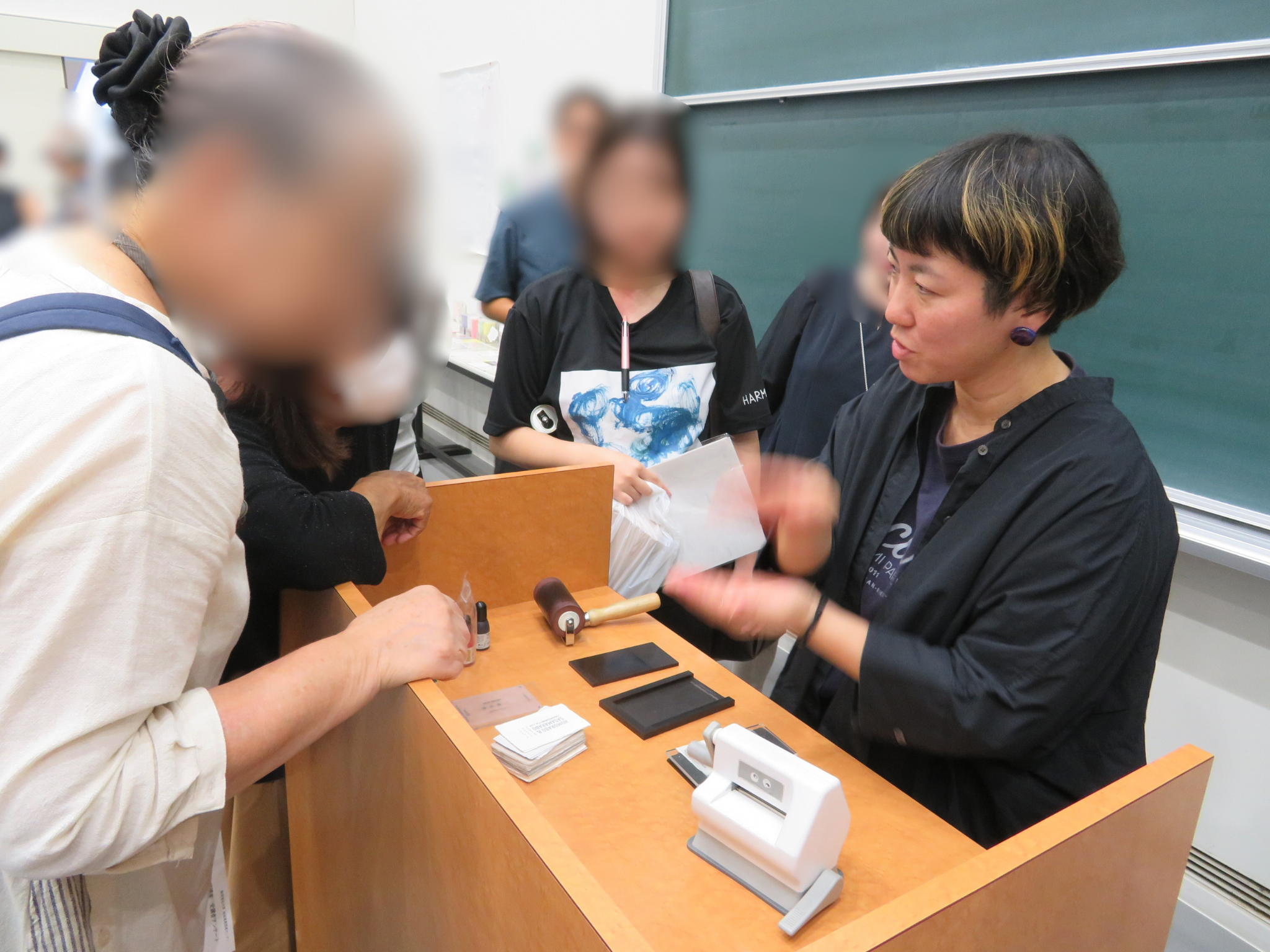 HUMOLABOの作品について説明を受けている様子