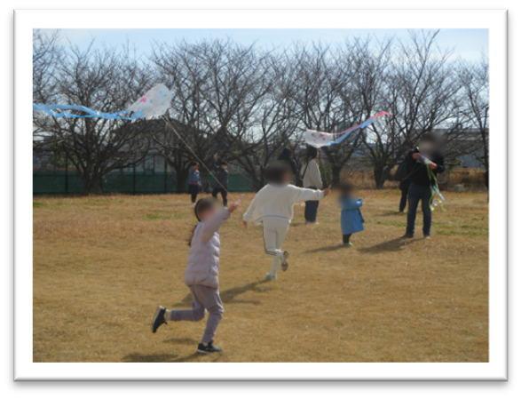 芝生で凧あげをしている様子